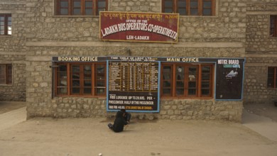 Ladakh bus operator cooperative stone building with signs and street view, Leh, Ladakh, North