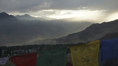 Prayer flags in foreground, mountains in sunset haze, Leh, Ladakh, North India, Himalayas, India