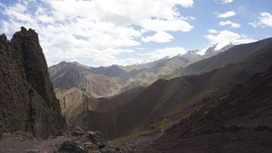 Wide mountain landscape with snowy peaks under cloudy sky, trekking at Stok La Pass in Ladakh,