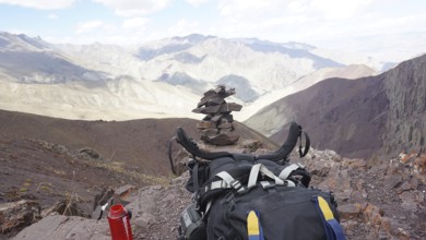 Break at the highest point of Stok La Pass, backpack in the foreground with rocky mountain scenery,