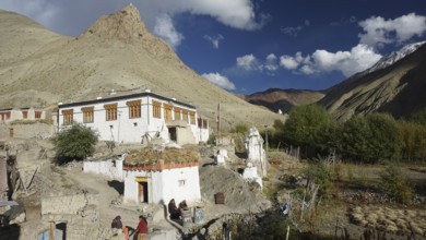 Traditional mountain village with colorful buildings under cloudy sky, trekking in Ladakh,