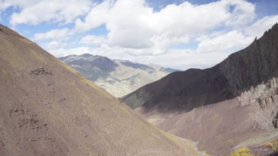 Mountain landscape with soft colors under a partly cloudy sky, trekking at Stok La Pass in Ladakh,