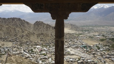Spectacular mountain view through wooden column with city view under the sky tent, Ladakh,