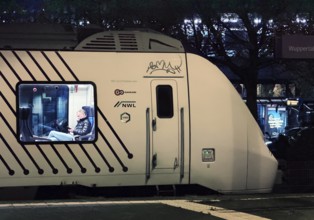 A person on a local train at Oberbamen station at night, Wuppertal, North Rhine-Westphalia, Germany