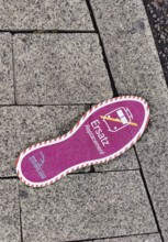 Purple footprint as a signpost on the pavement for rail replacement services, abbreviated SEV, Zug