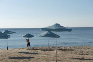 Varna, Bulgaria. September 5th 2020 Setting out sunshade umbrellas on the beach in Varna on the