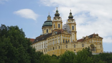 Baroque monastery in Melk surrounded by trees and sky, Melk, Austria