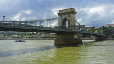 The Szechenyi Chain Bridge across the Danube under a cloudy sky, connection between Buda and Pest,
