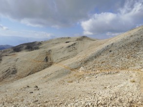 A narrow path snakes through a rocky mountain landscape, climbing Tahtali Dagi, Lycia, Turkey