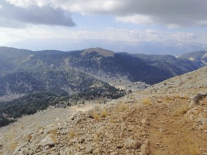Extensive mountain view with wooded slopes and a rocky trail climb of Tahtali Dagi, Lycia, Turkey