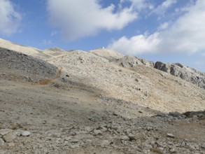 Rocky mountain landscape on Tahtali Dagi, peaks in sight, under a partly cloudy sky, climbing