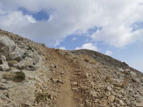 A rocky path snakes up Tahtali Dagi to the cloudy sky, climbing Tahtali Dagi, Lycia, Turkey