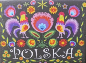 Colourful traditional Polish folk art with roosters and flowers on a black background and the