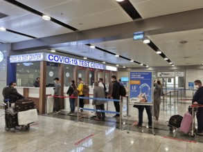 People are standing in a queue in front of a COVID-19 test center at the airport, Antalya, Turkey
