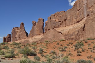 Jagged sandstone formations called Wall Street and sparse vegetation stretch under a clear sky in