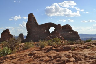 Turret Arch, a characteristic rock formation with an arch, surrounded by desert landscape and light