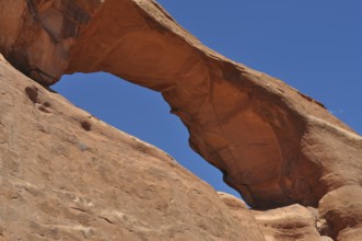 Skyline Arch, a massive sandstone arch in the desert under clear skies, Arches National Park, Utah,
