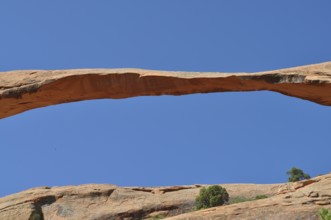 Close-up of a natural stone bridge, called Landscape Arch, against the blue sky, Arches National