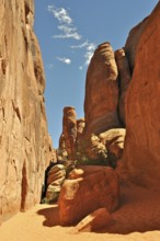 Narrow gorge surrounded by high rock walls with intense sunlight, Arches National Park, Utah, USA