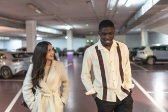 Diverse couple walking and smiling together through a modern underground parking garage after a