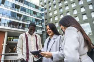 Diverse business professionals smiling and collaborating while reviewing data together on a