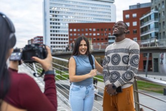 Camerawoman filming an interview with a female reporter holding a microphone and a young cheerful