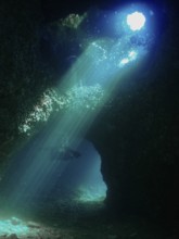 Rays of light illuminate the fascinating underwater cave that a diver explores. Fraskeric dive