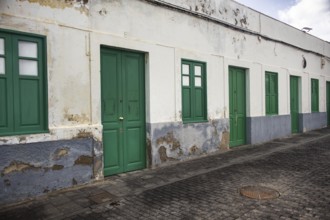 Long, single-storey row of houses in Arrecife, Lanzarote, taken from an oblique perspective. Broken