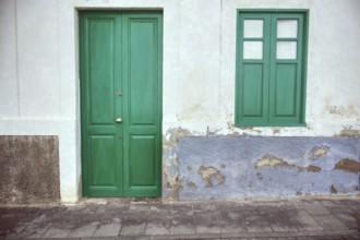 Landscape close-up of a green door and window in Arrecife, Lanzarote. Speckled plaster gives the