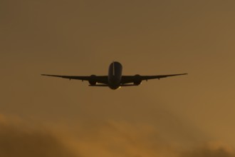 Boeing 777 A7-BFL commercial jet aircraft of Qatar cargo taking off in flight silhouette at sunset