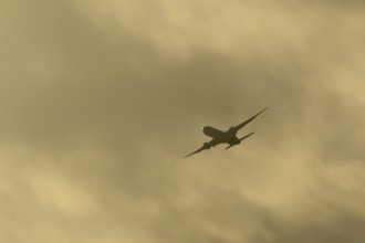 Commercial passenger airliner jet aircraft in flight at sunset at London Stansted airport, Essex,