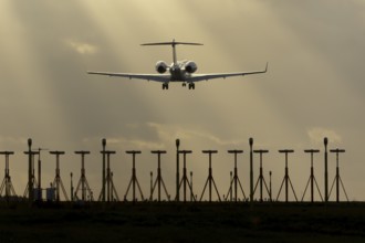 Executive business jet aircraft in flight on approach to land at sunset at London Stansted airport,