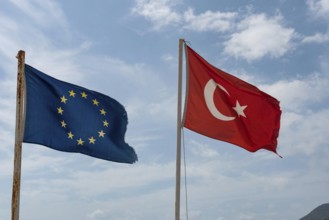 Alanya, Turkey. April 8th 2021 Tattered Turkish and European Flags flying on the beach in Alanya on