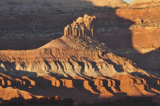 Rock formation in evening light with dramatic shadows in a barren desert landscape, Capitol Reef