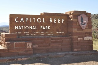 Capitol Reef National Park entrance sign, made of red bricks, surrounded by nature, Capitol Reef