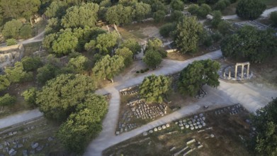 Soft morning light, Philippeion, ancient ruins and a round temple surrounded by trees and paths,