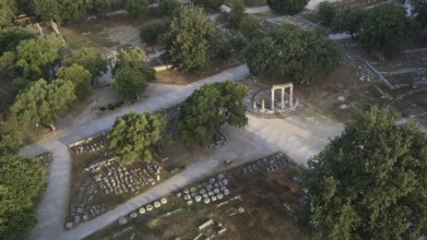 Soft morning light, Philippeion, ancient ruins with a round temple surrounded by paths and trees,