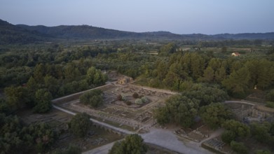 Leonidaion, archaeological ruins in landscape with trees and mountains in the background, drone
