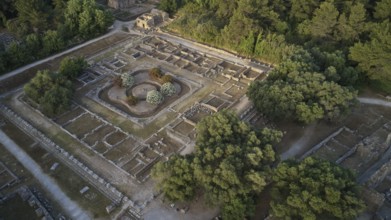 Leonidaion in morning light, aerial view of a rectangular ruin surrounded by trees at sunset, drone