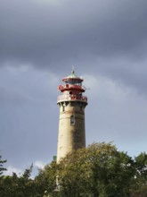 Lighthouse against cloudy sky, surrounded by trees, with an autumn atmosphere, Cape Arkona, Rügen