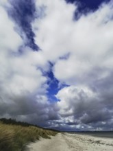 Dramatic sky with blazing clouds over a secluded beach with dunes, Rügen, Baltic Sea