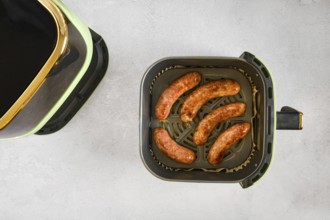 Natural casing sausages in an air fryer, being cooked at high heat. This activity shows the process
