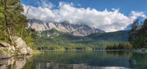 View over Lake Eibsee lake, the Wetterstein Mountains with the Zugspitze in the background, clouds