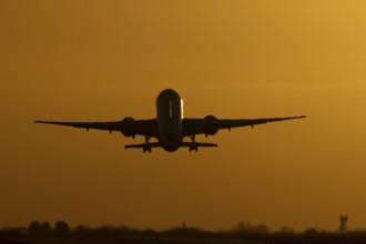 Boeing 777 A7-BFL commercial jet aircraft of Qatar cargo taking off in flight silhouette at sunset