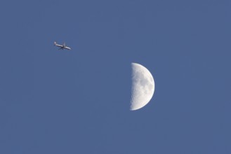 Airbus commercial passenger airliner jet aircraft of British airways in flight with the moon in the