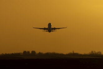 Airbus commercial passenger airliner jet aircraft taking off in flight at sunset at London Stansted