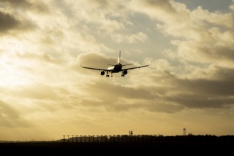 Boeing 737 commercial passenger airliner jet aircraft flying on approach to land over runway lights