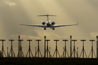 Executive business jet aircraft in flight on approach to land at sunset at London Stansted airport,