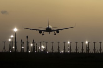 Airbus 320 commercial passenger airliner jet aircraft in flight on approach to land over runway