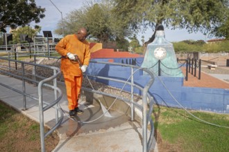 Phoenix, Arizona - A prisoner cleans a sidewalk in Wesley Bolin Memorial Plaza, a public park next